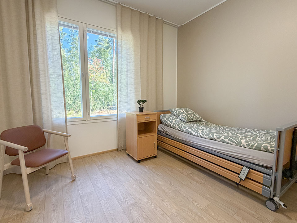 Gunnarlan asukashuone, sänky ja tuoli, vaaleat pinnat