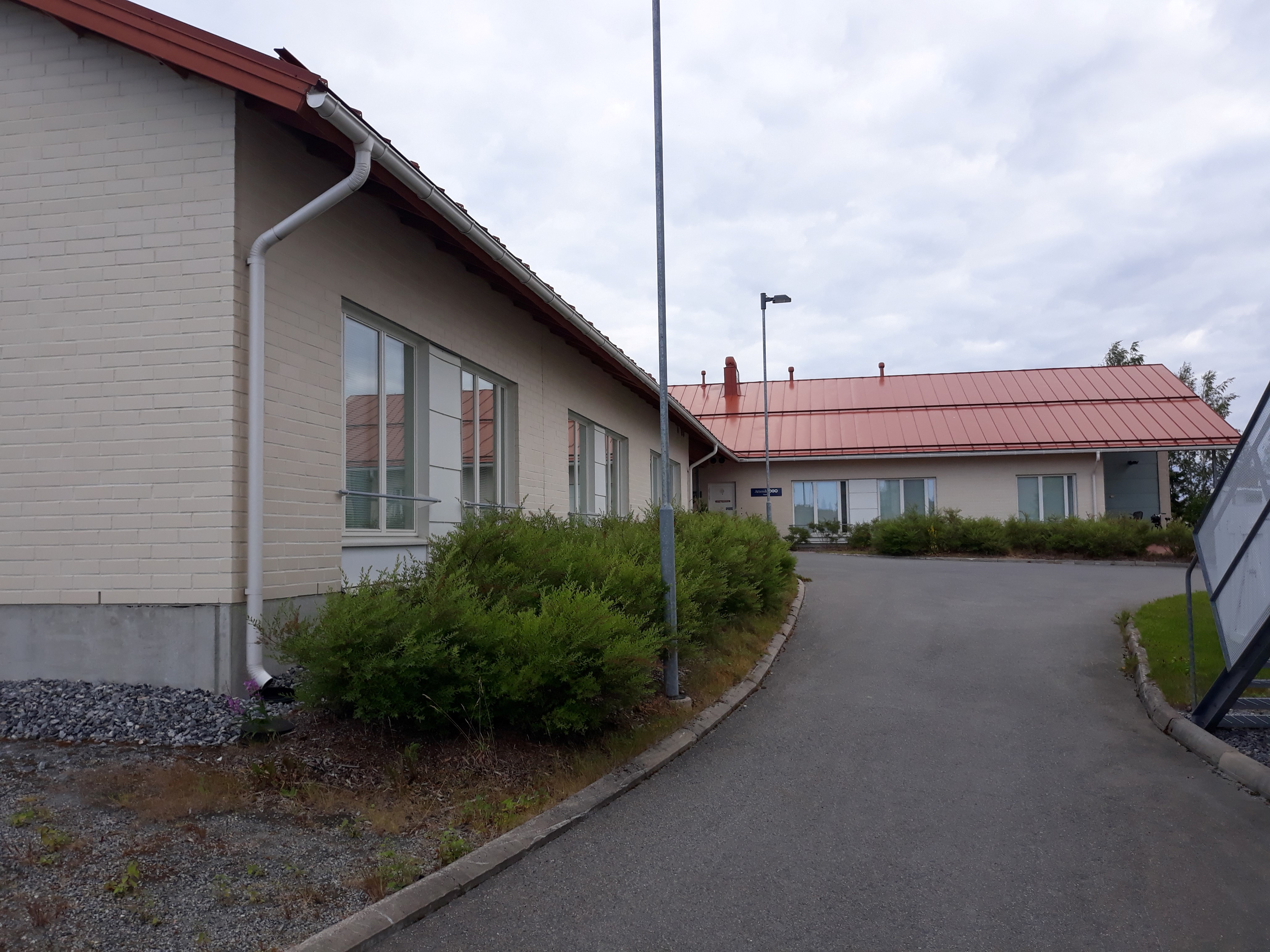 Saariston yksikerroksinen, vaalea rakennus ulkoa