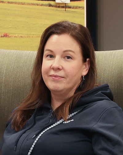 Tytti Ikävalko istuu vihreällä nojatuolilla sininen huppari päällä