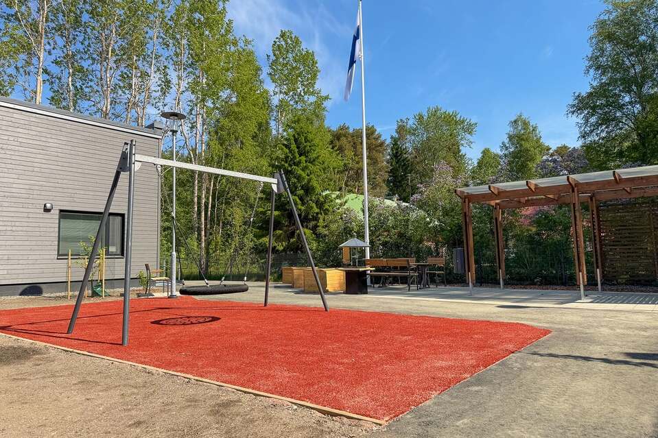 Kotojärven pihalla keinu, jonka alla punainen mattoalue