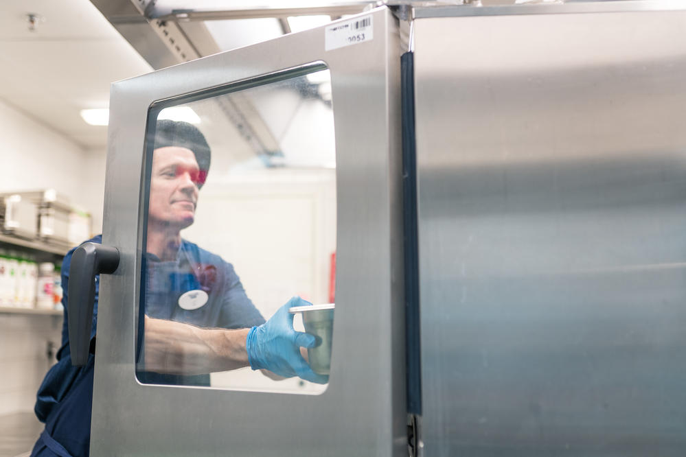 Attendon kokki ottaa ruokaa pois suurkeittiöuunista