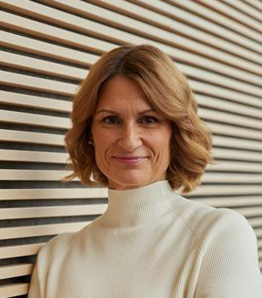 Eveliina katsoo kameraan, päällään vaalea poolopaita 